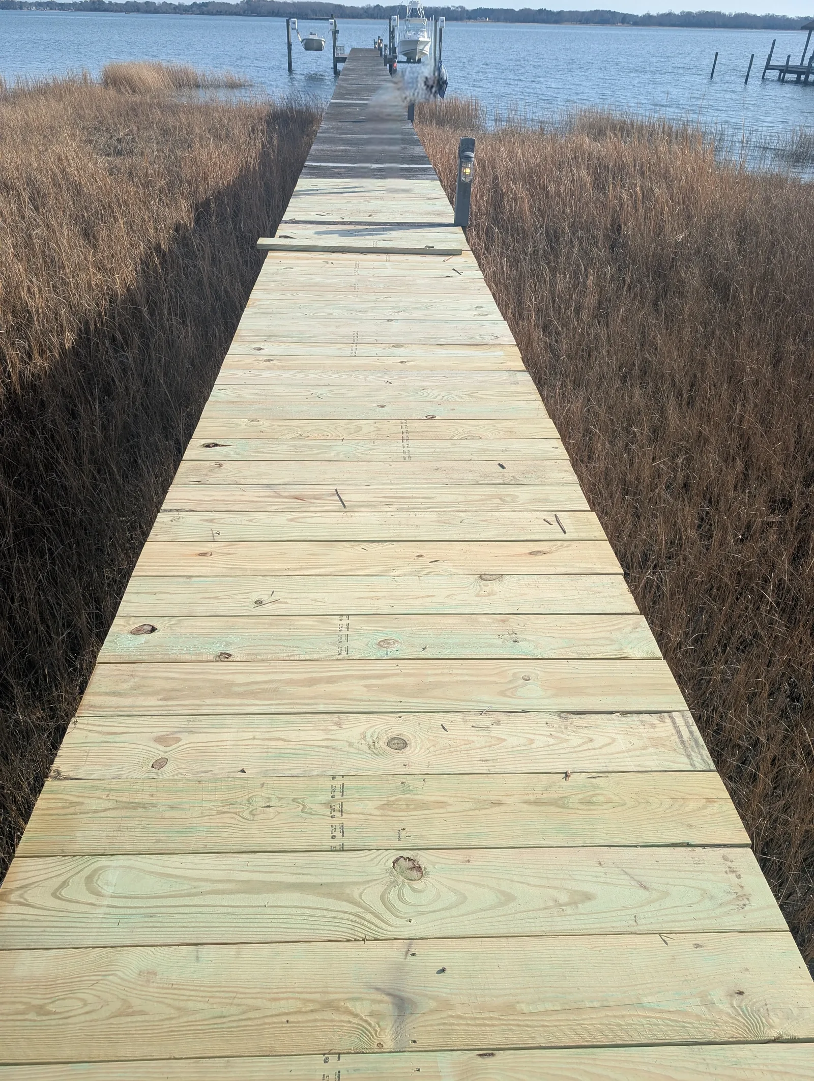 New pressure-treated decking on an existing residential pier walkway